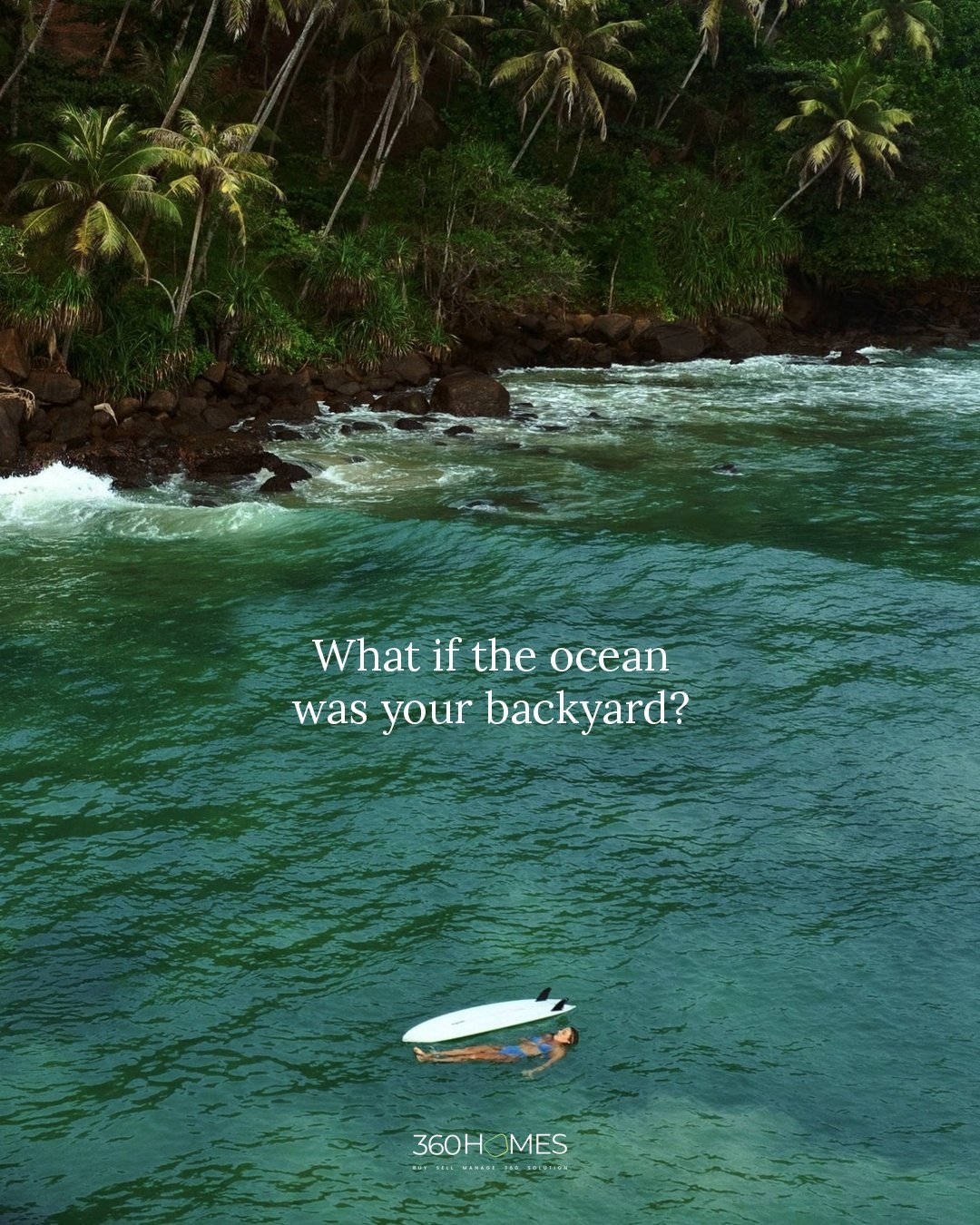 What if the ocean was your backyard? A swimmer floating in a turquoise bay by a palm-lined shore